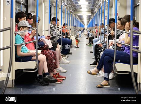 Crowd Of People In A Metro Train In Summer Passengers Sits With