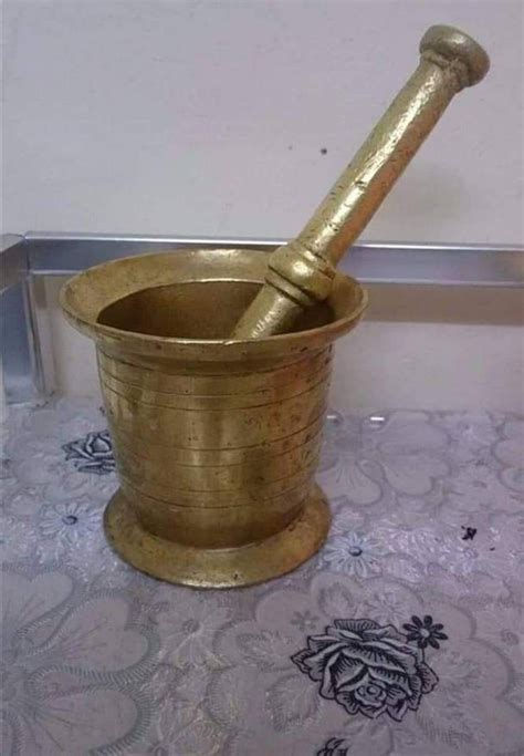 An Old Brass Mortar And Pestle On A Table