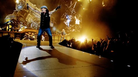 Man Wearing Black Vest White Holding Microphone On Stage Near Crowd White Performing Hd