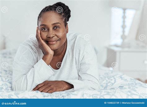 Femme Africaine De Sourire Se Trouvant Sur Son Lit Pendant Le Matin