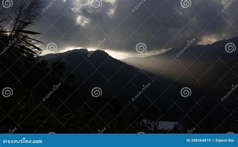 Bright Sunlight Shining Through Hole Of Clouds To Dark Scene Of