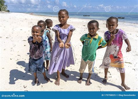 A Group Of African Children Begs Money From Tourists On A Sandy Beach