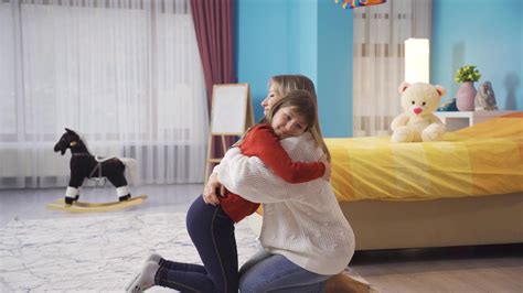 Happy loving mother and little daughter enjoying hug, hug in bedroom ...