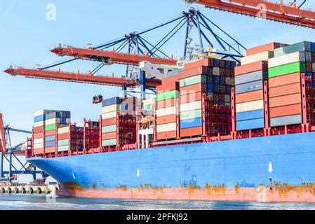 A Cargo Ship Loaded With Colorful Containers Sails Through A Vast Sea