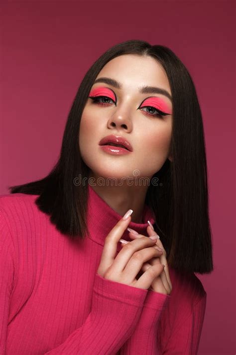 Beautiful Brunette Woman In Pink Clothes With Pink Fashion Make Up Posing In The Studio