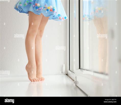 Little girl barefoot window Banque de photographies et dimages à haute