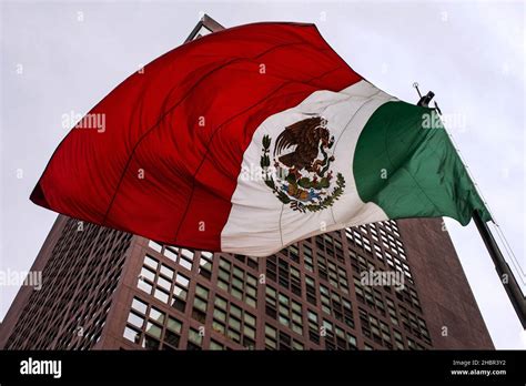 Un tiro de ángulo bajo de la bandera mexicana al lado de un edificio