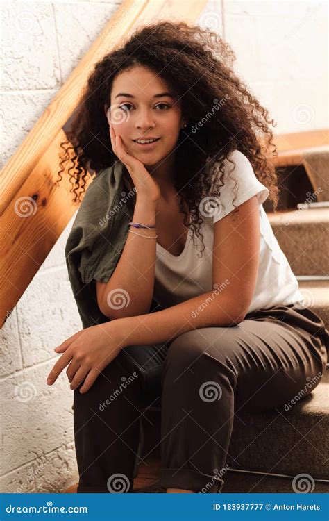 Joven Y Hermosa Mujer Sonriente Con Pelo Rizado Oscuro Sentada En Las Escaleras En La