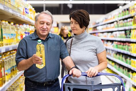 Pareja De Ancianos Casados Eligiendo Aceite De Girasol Juntos En El