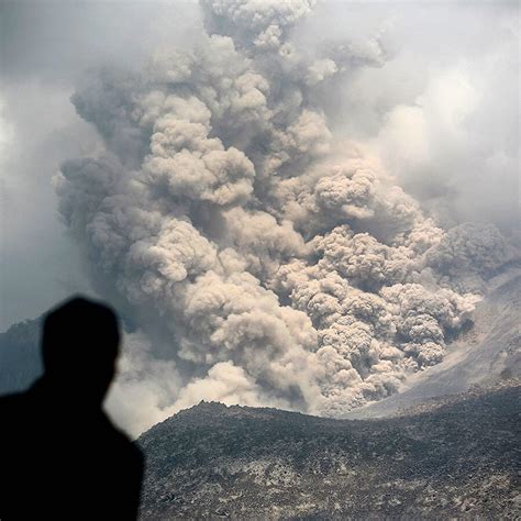 An Indonesian Man Watches As A Pyroclastic Flow Sweeps Down The Slope