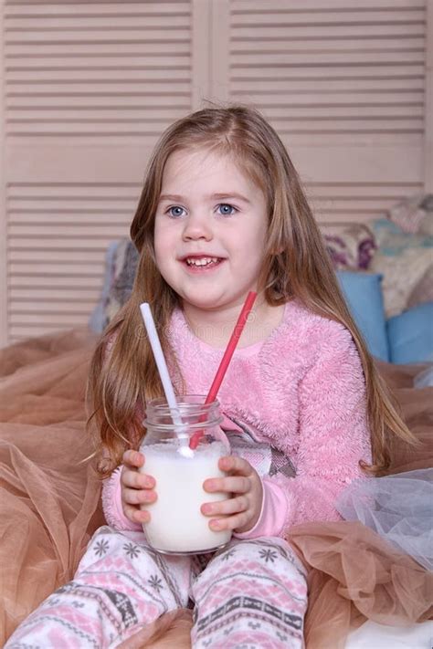 Une Gentille Petite Fille Blonde Sur Le Lit Photo Stock Image Of Adorable Lait