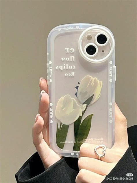 A Woman Holding Up A Phone Case With Flowers On It And The Words