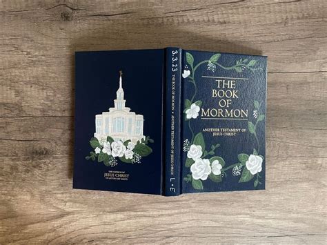 The Book Of Mormon Sits On A Wooden Table