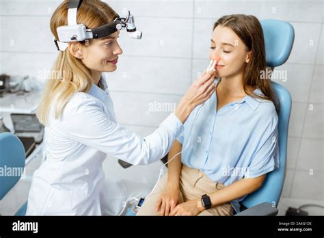 Female Otolaryngologist Making Physiotherapy Procedure For The Nose Of