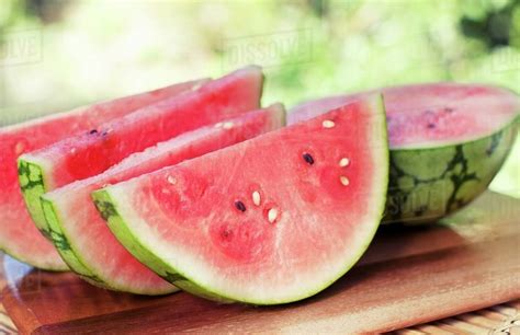 Watermelon Slices And Half A Watermelon On A Cutting Board Outdoors