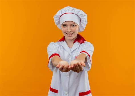 Jovem Chef Loira Sorridente Uniforme De Chef Segurando Ovos