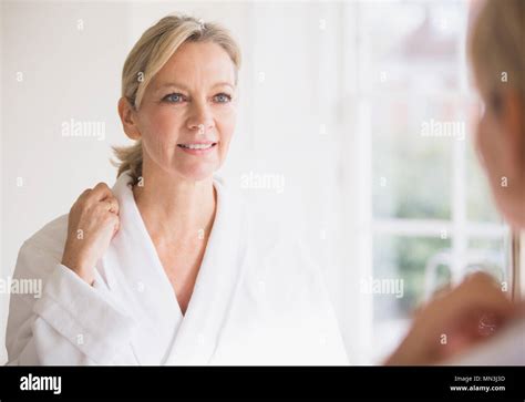 Smiling Mature Woman In Bathrobe At Bathroom Mirror Stock Photo Alamy