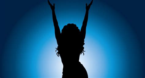 Silhouette Of Long Haired Woman Holding Hands Up At Blue Background