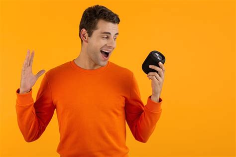 Premium Photo Stylish Smiling Young Man In Orange Sweater Holding