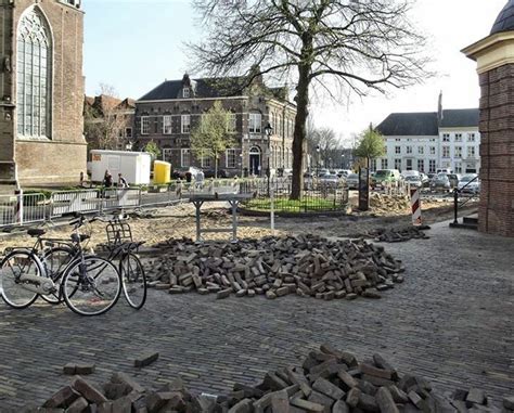 Two Bikes Parked Next To Each Other On A Cobblestone Area With