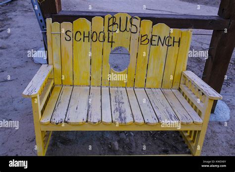 A Yellow Wooden School Bus Stop Bench In A Rural Southern California