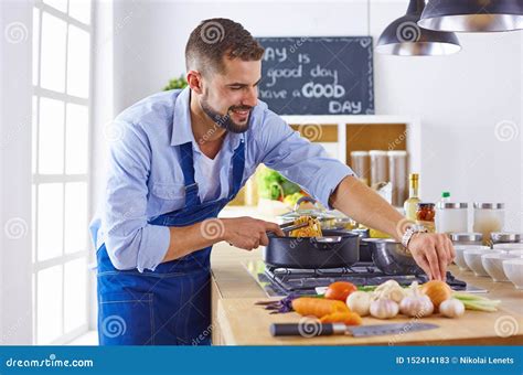 Sonrisa Y Cocinero Confiado Que Se Colocan En Cocina Grande Imagen De