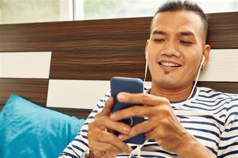 Premium Photo Excited Handsome Young Asian Man Listening To Music Via