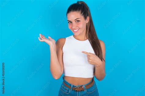 Beautiful Brunette Woman Wearing White Tank Top Over Blue Background