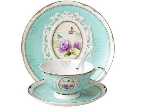 A Tea Cup And Saucer Set With Purple Roses