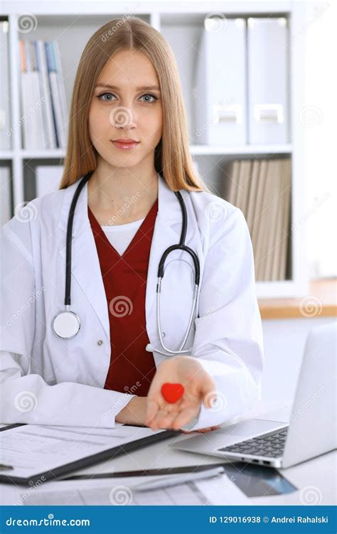 Female Doctor with Stethoscope Holding Heart in Her Arms. Healthcare ...