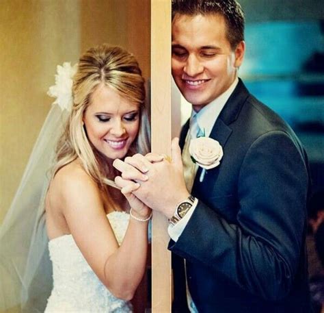 A Man And Woman Standing Next To Each Other In Front Of A Mirror