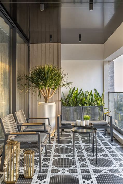 A Balcony With Chairs Tables And Potted Plants