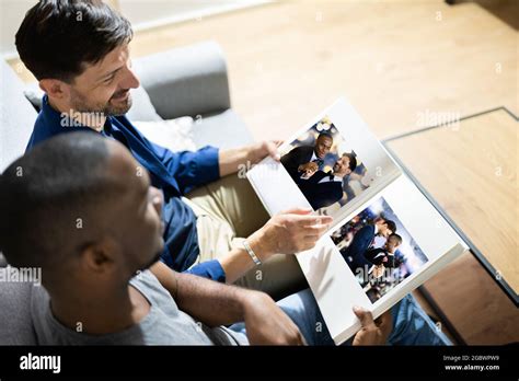 Gay Couple Looking Photo Album Or Photobook Stock Photo Alamy