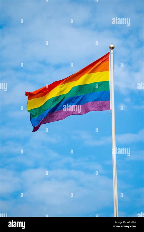 The Rainbow Flag Against A Blue Sky Gay Pride Flag Or LGBTQ Pride Flag A Symbol Of Lesbian