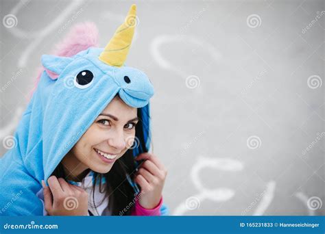 Beautiful Young Woman Wearing Turquoise Unicorn Onesie In Urban