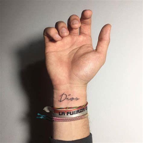 "Dios" lettering tattoo on the wrist