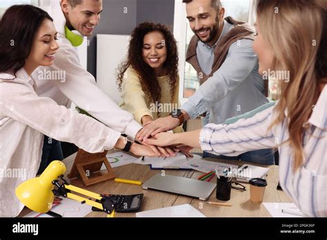 Team Of Employees Putting Hands Together In Office Startup Project