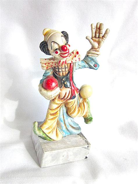 A Statue Of A Clown Holding His Hand Up