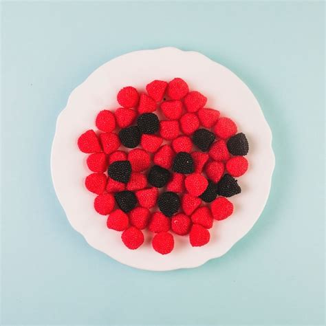 Bonbons Aux Canneberges Rouges Et Noirs Sur Une Assiette Photo Gratuite