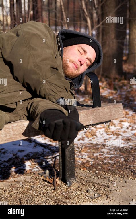 Homeless Man Sleeping On Park Bench On Cold Winter Day Stock Photo Alamy