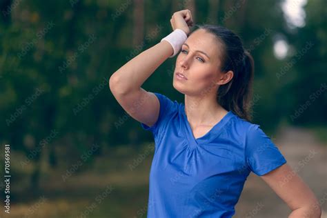 Athletische Frau wischt sich den Schweiß aus dem Gesicht Stock Photo