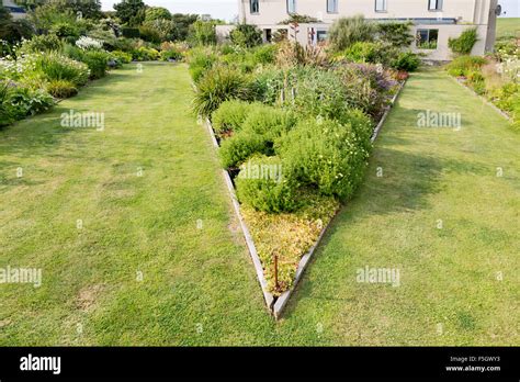 Triangular Raised Flower Bed On Large Garden Lawn Stock Photo Alamy