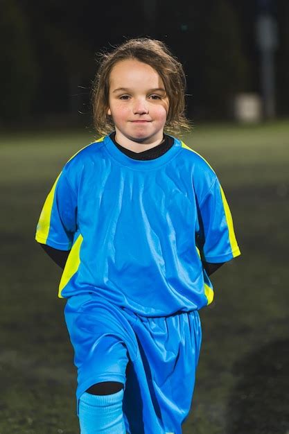 Premium Photo | Little and super cute caucasian girl wearing a football blue uniform and posing ...