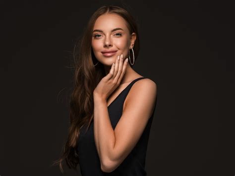 Premium Photo Beautiful Woman With Long Healthy Curly Brunette Hair Earrings Black Dress Black