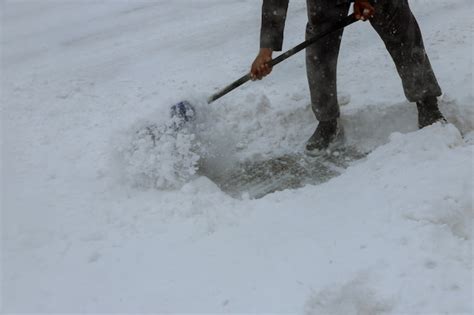 Premium Photo | Workers sweep snow from road in winter, cleaning road from snow storm.