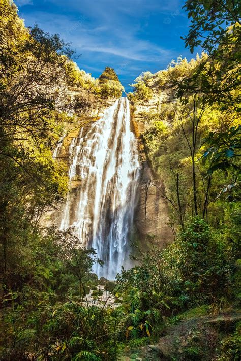 Premium Photo | Tall waterfall cascading over the edge of the cliff in ...