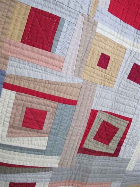 A Close Up Of A Quilt With Squares And Rectangles In Red Yellow Grey