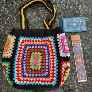 A Crocheted Bag And Some Other Items Are On The Floor Next To It