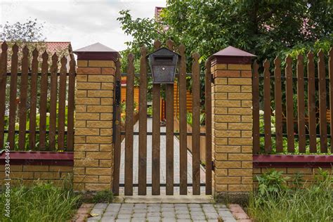 Wooden wicket gate. Wooden fence with with brick pillars Stock Photo ...