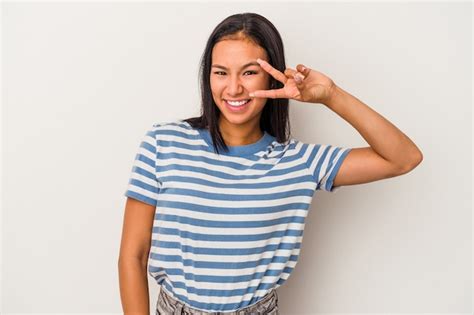 Mujer latina joven aislada sobre fondo blanco bailando y divirtiéndose Foto Premium